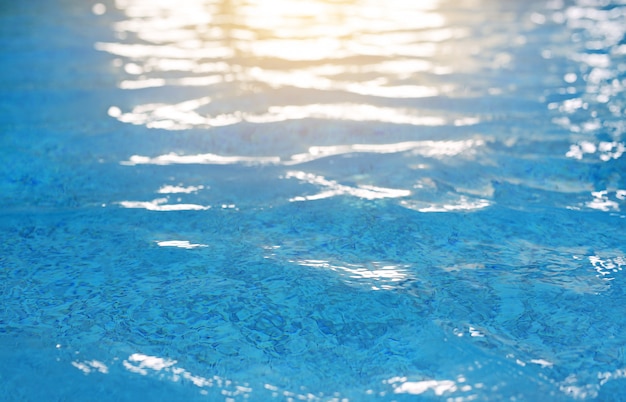 Ondulations abstraites sur la surface de la piscine avec réflexion de la lumière.