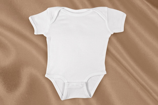 Onesie Mockup sur tissu doré élégant