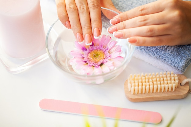 Ongles de belle femme avec manucure française en studio de beauté