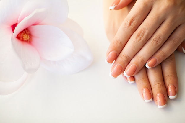 Ongles de femme belle avec manucure française, en studio de beauté