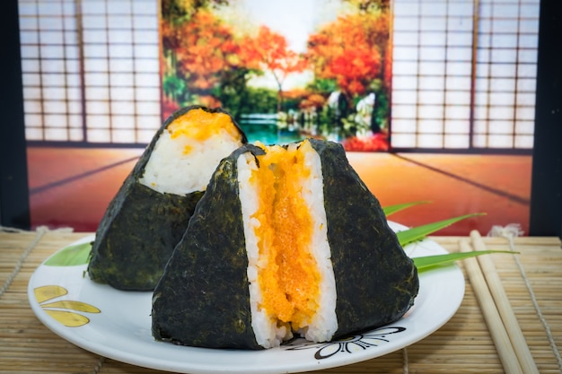 Onigiri japonais sur plat et tapis traditionnel aux oeufs