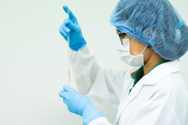 Photo l'opérateur ajuste le volume d'eau dans une pipette volumétrique.