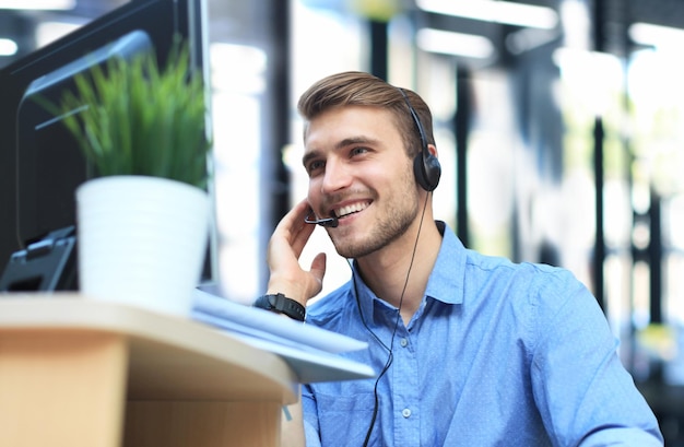 Opérateur de centre d'appels beau jeune homme souriant et sympathique