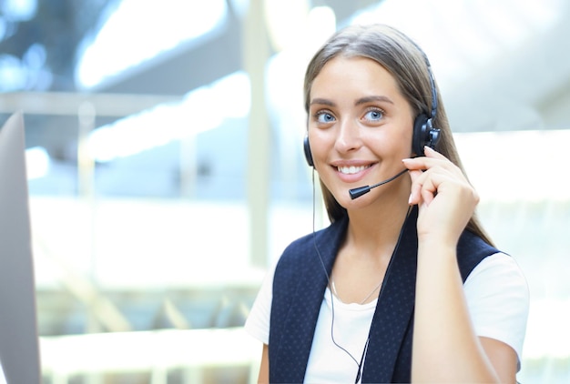 Opérateur de centre d'appels belle jeune femme avec casque au bureau.