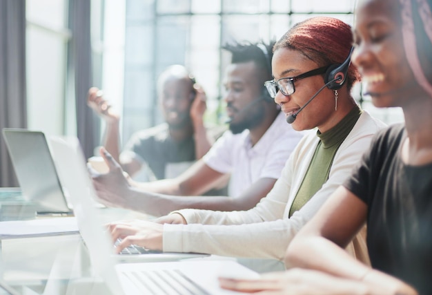 Opérateur de centre d'appels avec des collègues sur le lieu de travail