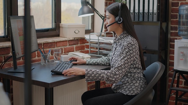 Opérateur de centre d'appels parlant aux clients lors d'un appel téléphonique avec microphone à la société de service client. Employé utilisant des écouteurs avec microphone lors d'un appel d'assistance et d'assistance au bureau d'affaires.