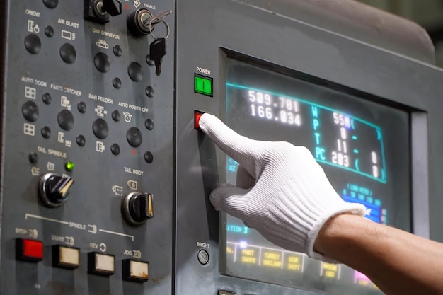 Opérateur de machine CNC Appuyez sur le bouton pour éteindre la machine en cas de défautUsine de pièces automobiles