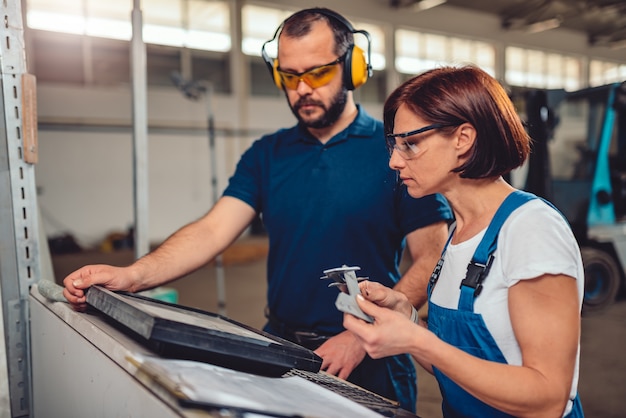 Opérateur de machine CNC vérifiant le produit fini