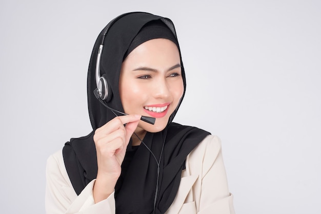 Opérateur de service client femme musulmane en costume portant un casque sur fond blanc studio