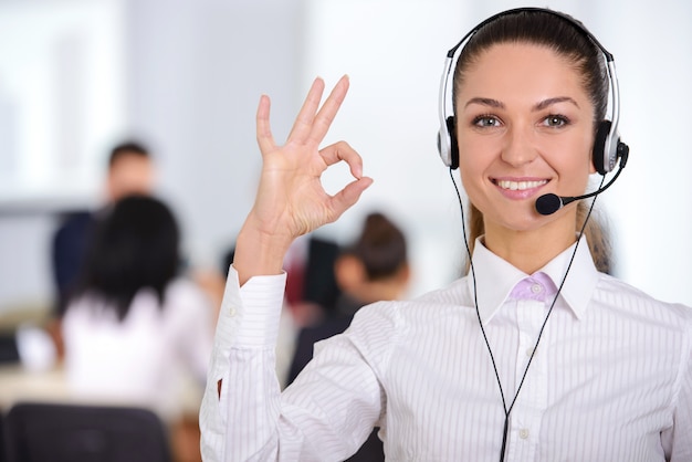 Opérateur de soutien à la clientèle féminine avec casque et souriant.