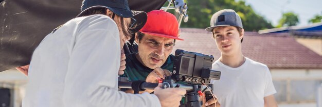 L'opérateur Steadicam et son assistant préparent la caméra et le stabilisateur 3 axes pour un tournage commercial BANNER LONG FORMAT