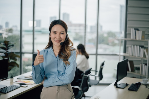 Opérateur de support client ou centre d'appels pour femmes asiatiques avec casque regardant devant et souriant