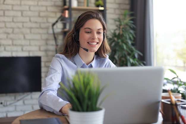 Opérateur de support client féminin avec casque et souriant.