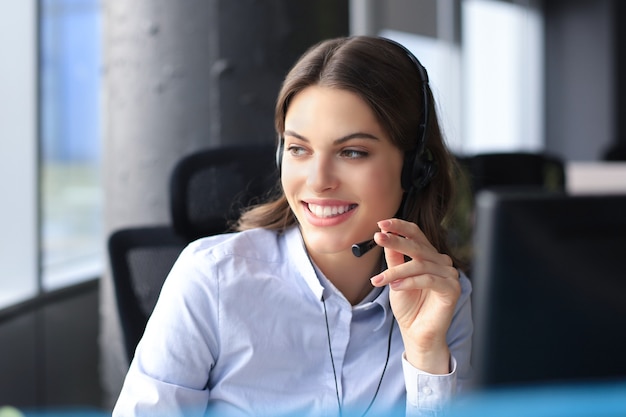 Opérateur de support client femme avec casque et souriant.