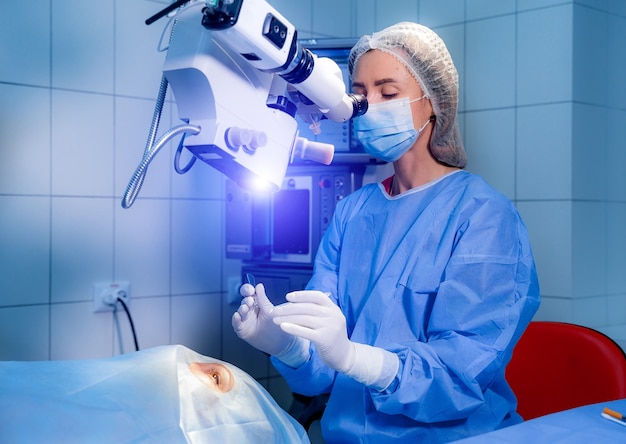 Opération de l'œil. Un patient et un chirurgien en salle d'opération lors d'une chirurgie ophtalmique. Patient sous microscope chirurgical. Correction de la vue