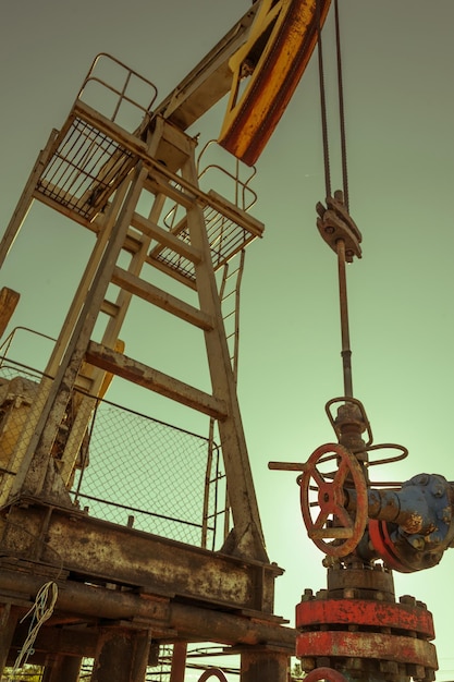 Opération de plate-forme de pompe à huile sur la plate-forme dans l'industrie pétrolière et gazière. Pumpjack, équipement industriel. Site du champ pétrolifère, la pompe à huile fonctionne. Machines à bascule pour la production d'électricité. Notion de pétrole. Tonifié.