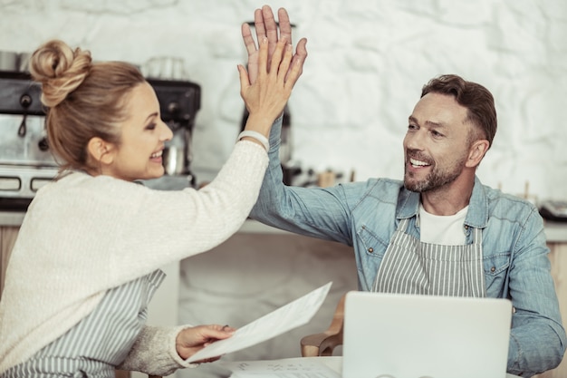 Opération réussie. Homme d'affaires souriant donnant un high-five à sa belle partenaire après une journée de travail productive.