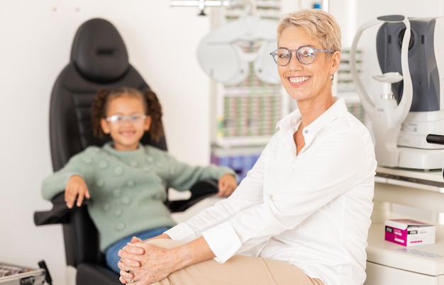 Ophtalmologiste enfant patient et test de vision ou examen de la vue pour les soins oculaires afin de vérifier et d'examiner la vue dans une clinique ou un magasin d'optométrie Portrait d'une femme médecin ou d'un spécialiste prêt pour les soins d'optique