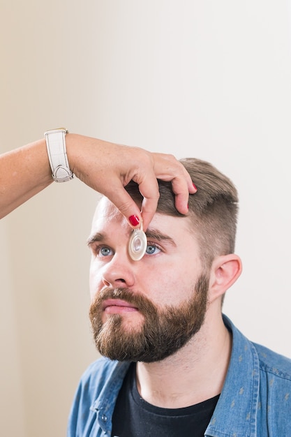 L'ophtalmologiste examine les yeux du patient.