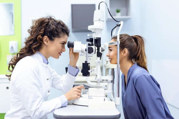 Ophtalmologiste avec une patiente lors d'un examen dans une clinique moderne L'ophtalmologiste utilise un équipement médical spécial pour sauver et améliorer la santé des yeux