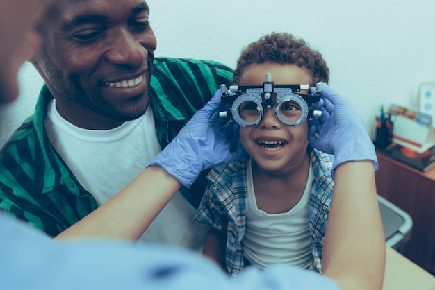 Ophtalmologiste Père afro-américain avec son fils à la réception