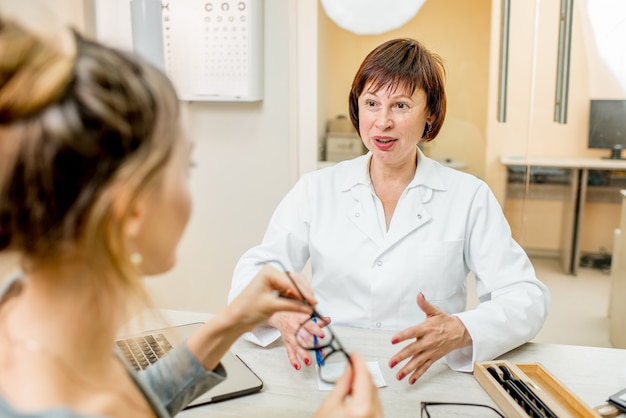 Ophtalmologiste senior femme avec jeune patiente lors de la consultation au cabinet ophtalmologique