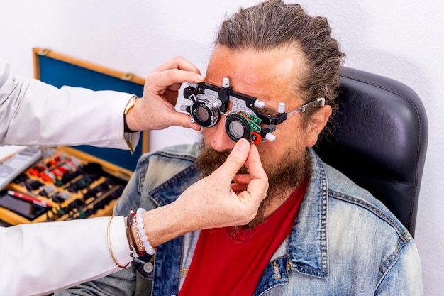 Un ophtalmologiste vérifie la vue de son patient avec une paire de lunettes de mesure