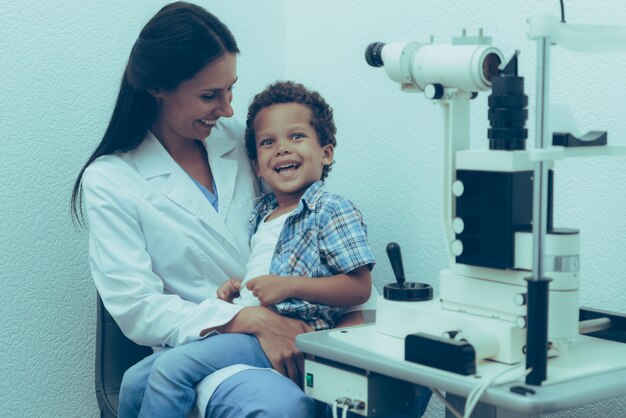 Un ophtalmologue examine les yeux d&#39;un patient garçon