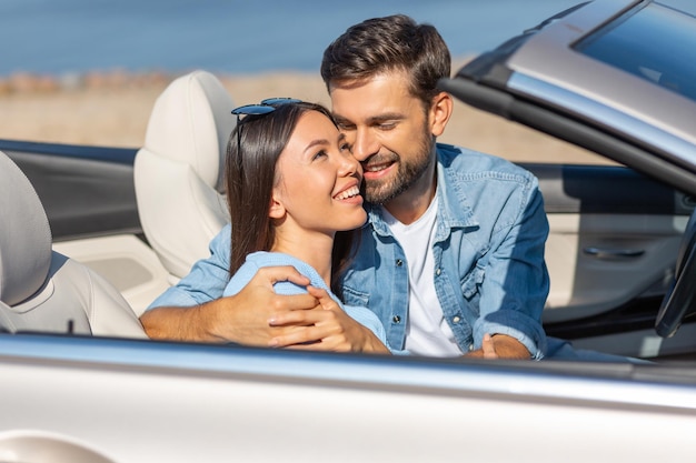 Oportrait d'un homme adulte étreignant une femme assise dans la voiture