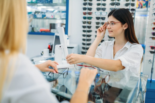 Opticien et consommateur choisit une monture de lunettes