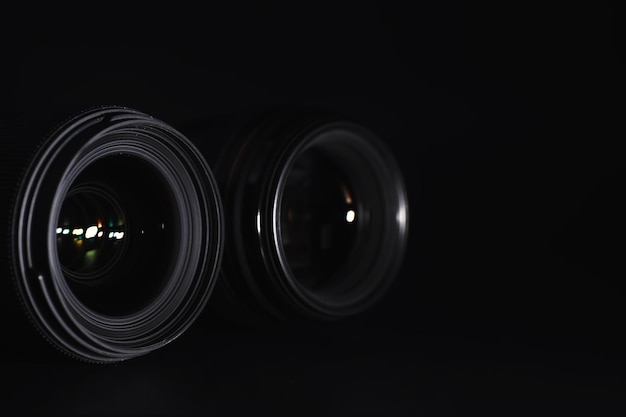 Optique à la caméra sur le bureau de l'opérateur Flare dans le verre d'un objectif photo Fond noir avec la technique du photographe