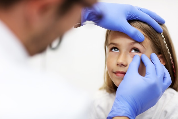 Optométrie enfant optométriste opticien médecin médecin examine la vue d'une petite fille