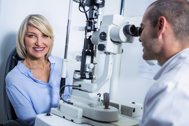Photo optométriste examinant une patiente sur une lampe à fente