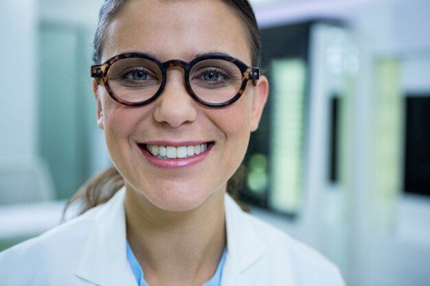 Optométriste en lunettes souriant dans un magasin d'optique