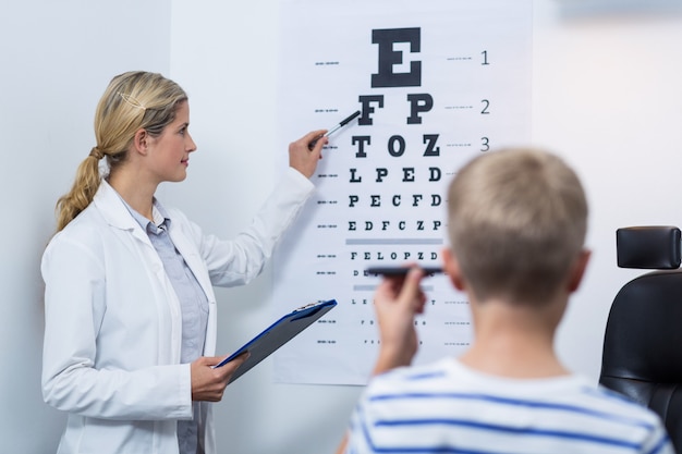Optométriste prenant test oculaire de jeune patient