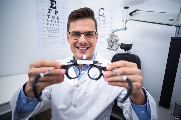 Optométriste souriant tenant messbrille