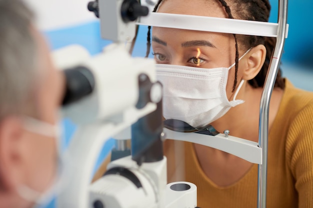 Optométriste utilisant une lampe à fente pour voir les structures de l'œil du patient telles que la cornée, l'iris et la lentille pendant l'examen