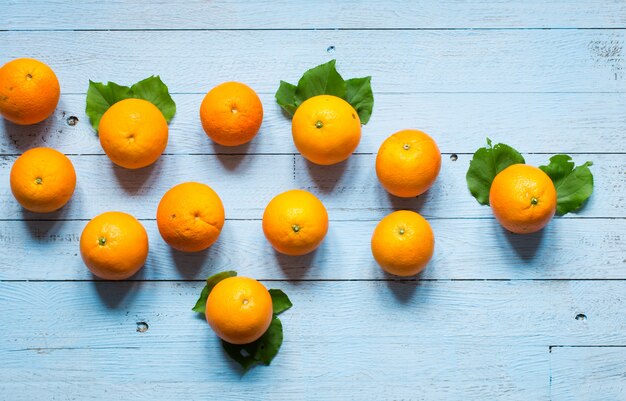 Orange douce avec des feuilles sur fond en bois.