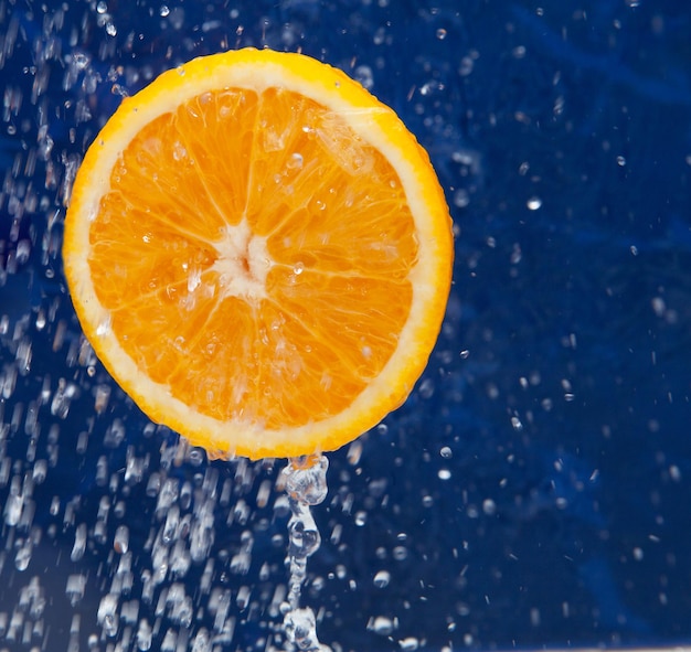 Orange douce fraîche sous des gouttes d'eau