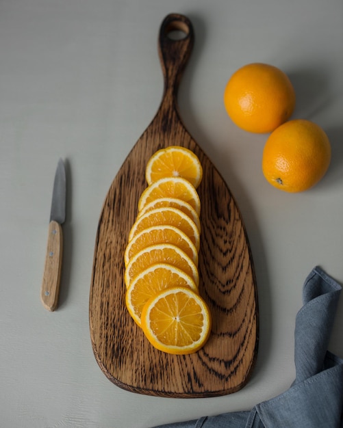 L'orange est coupée en tranches rondes sur une planche