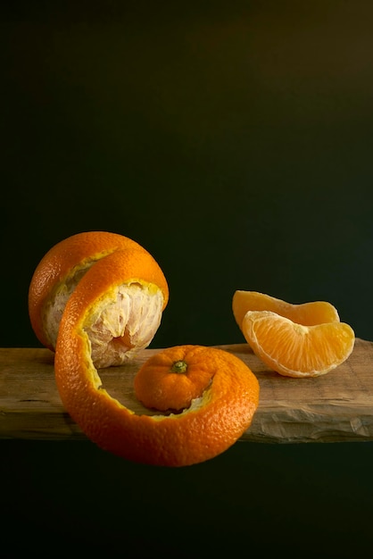 Orange sur une étagère en bois sur fond sombre.