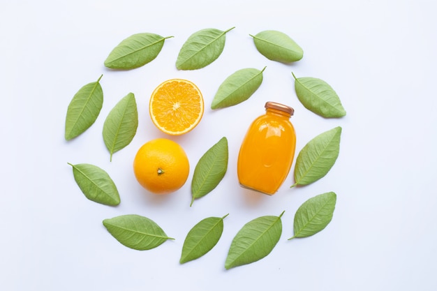 Orange avec des feuilles vertes et jus d&#39;orange isolé sur fond blanc. Vue de dessus