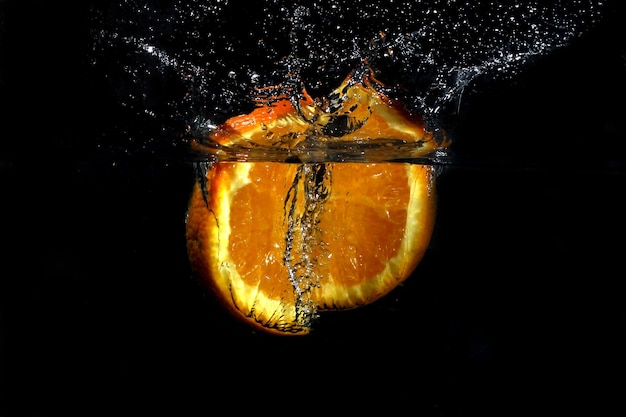 L'orange fraîche est tombée dans l'eau