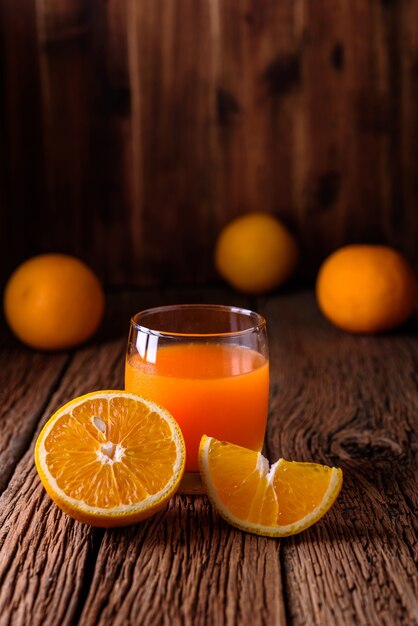 Orange juce et orange sur la vieille table en bois