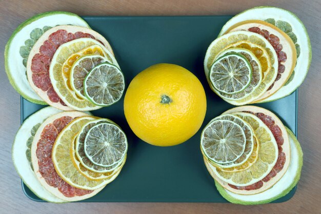 Orange avec des morceaux d'agrumes séchés sur une assiette