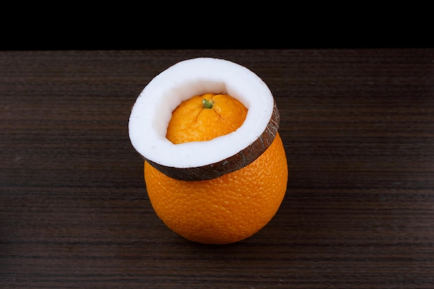 Orange et noix de coco sur fond en bois. Fruits frais