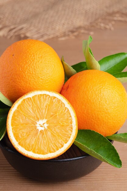 Orange.orange fruits fond de nombreux fruits orange. Groupe d'oranges fraîchement cueillies dans un panier et sur une table en bois marron