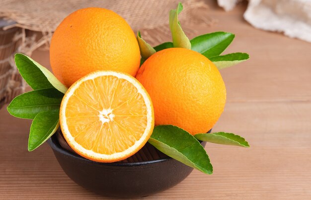 Orange.orange fruits fond de nombreux fruits orange. Groupe d'oranges fraîchement cueillies dans un panier et sur une table en bois marron