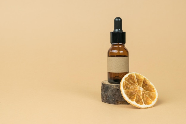 Orange séchée et une bouteille avec une pipette sur la taille d'un vieil arbre sur fond beige Cosmétiques et médicaments à base de minéraux naturels