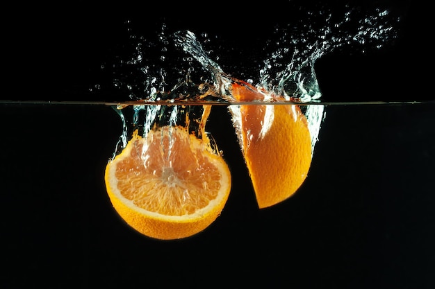 Orange tombe dans l'eau et fait des éclaboussures